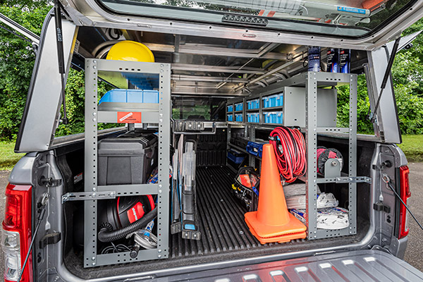 a pickup truck fully upfitted with Adrian Steel pickup truck equipment including shelving units and other accessories