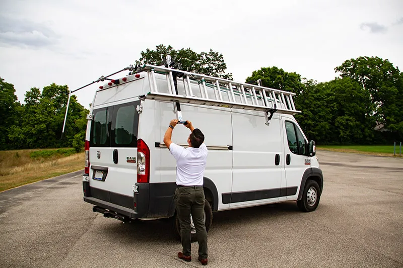 technician dismounting a ladder from an Adrian Steel ladder rack on a RAM ProMaster