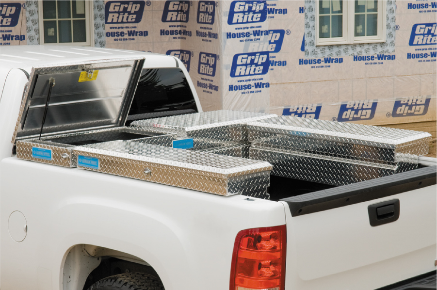 A white pickup truck upfitted with several Adrian Steel tool boxes